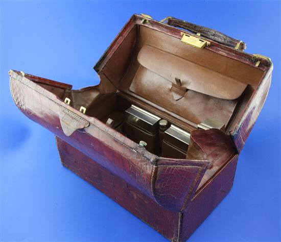 An early 20th century Cartier gilt metal mounted crocodile skin Doctors travelling toilet case